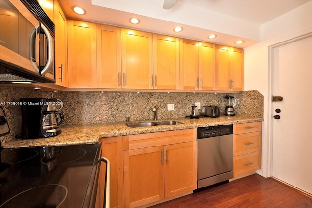 kitchen featuring dark wood-type flooring, stainless steel appliances, light stone countertops, decorative backsplash, and sink