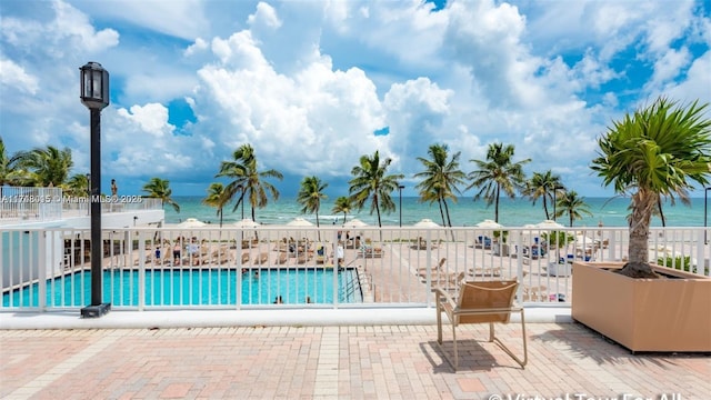 view of pool with a patio and a water view