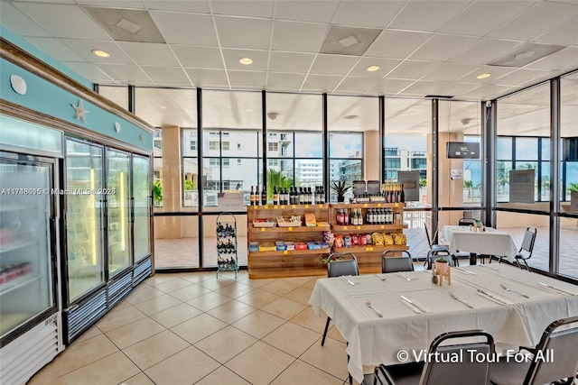 interior space featuring tile patterned floors, a paneled ceiling, and floor to ceiling windows