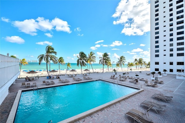 view of swimming pool featuring a patio area and a water view