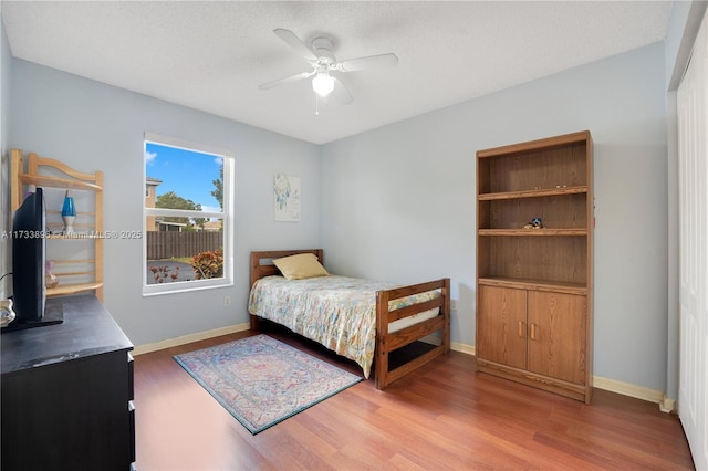 bedroom featuring hardwood / wood-style flooring, ceiling fan, and a textured ceiling