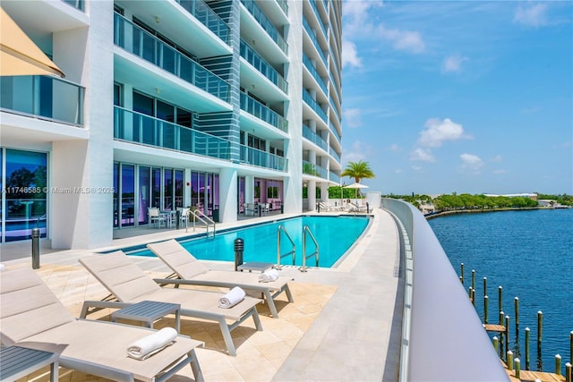 view of pool with a water view and a patio