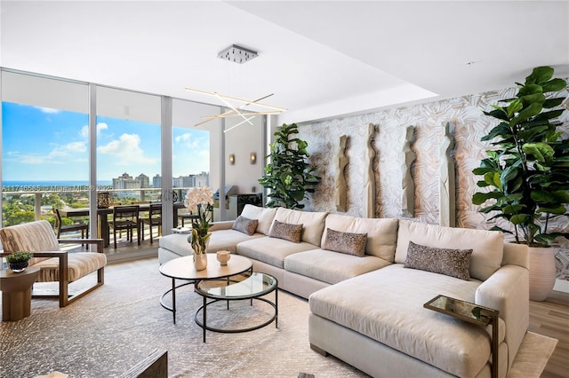 living room featuring a chandelier, wood-type flooring, and expansive windows