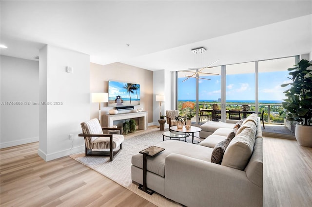 living room featuring a wall of windows and light hardwood / wood-style floors