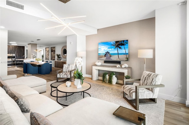 living room featuring light hardwood / wood-style floors and a chandelier