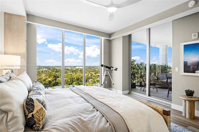 bedroom with multiple windows, access to exterior, ceiling fan, and wood-type flooring