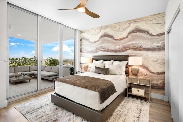 bedroom featuring ceiling fan, light hardwood / wood-style flooring, and access to exterior