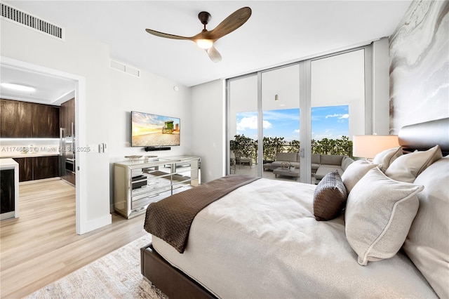 bedroom featuring ceiling fan, access to exterior, floor to ceiling windows, and light hardwood / wood-style floors