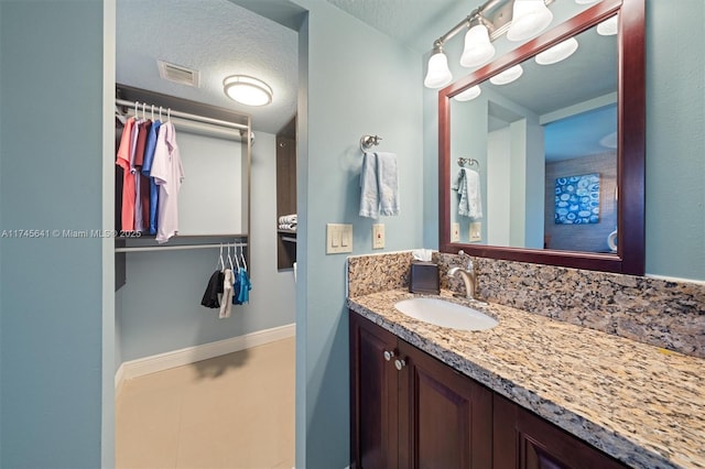 2631 Marathon, Fort Lauderdale, FL 33312 - bathroom featuring baseboards, a textured ceiling, vanity, and a walk in closet