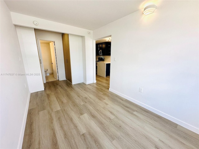 empty room with light wood finished floors and baseboards