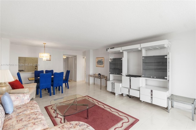 living area with a chandelier, a textured ceiling, and light tile patterned floors