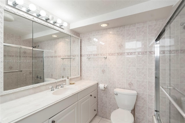 bathroom featuring a stall shower, vanity, and tile walls