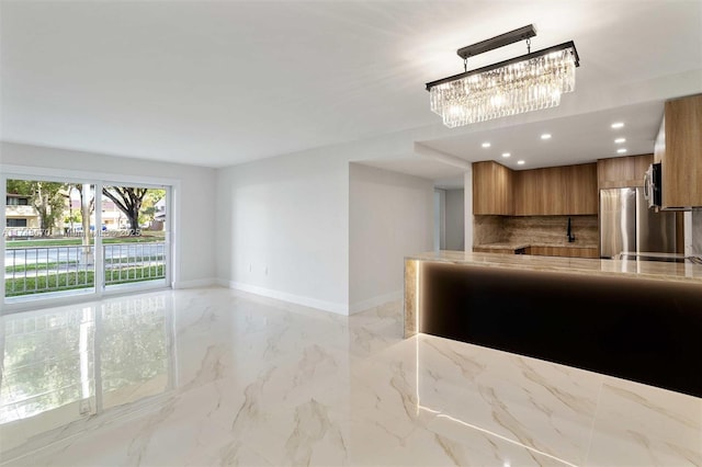 kitchen featuring stainless steel fridge, kitchen peninsula, tasteful backsplash, and hanging light fixtures