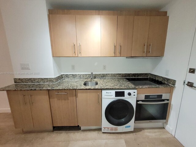 10275 Collins Ave Unit 111, Bal Harbour, FL 33154 - kitchen featuring dark stone countertops, oven, sink, and washer / clothes dryer