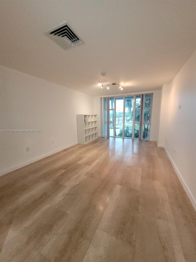 10275 Collins Ave Unit 111, Bal Harbour, FL 33154 - spare room with wood-type flooring and expansive windows