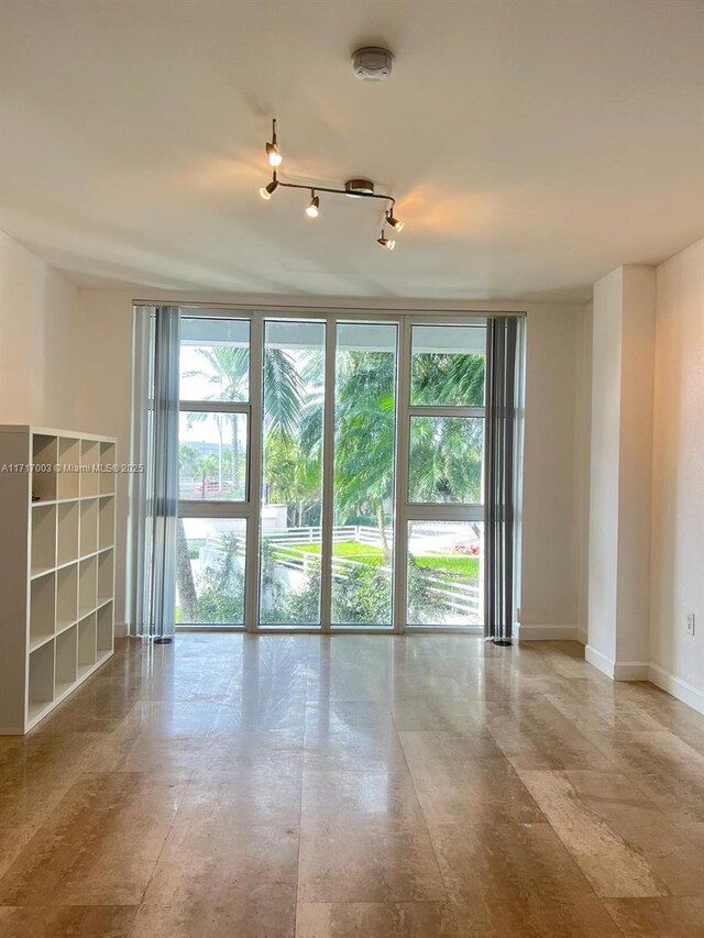 10275 Collins Ave Unit 111, Bal Harbour, FL 33154 - empty room featuring track lighting and expansive windows