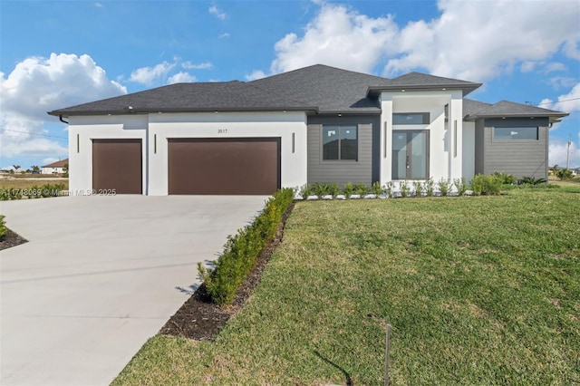 prairie-style home with concrete driveway, an attached garage, and a front yard