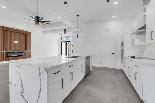 kitchen featuring black electric cooktop, a sink, wall chimney range hood, stainless steel dishwasher, and a glass covered fireplace