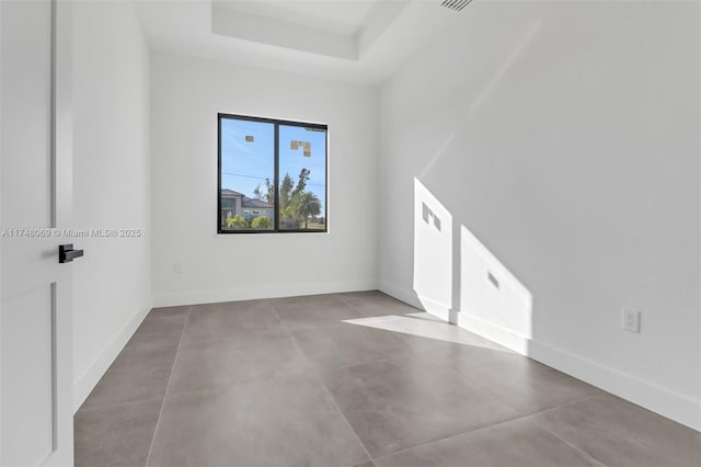 interior space with baseboards and a tray ceiling