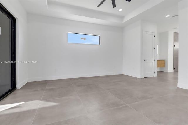 spare room with ceiling fan, baseboards, a raised ceiling, and recessed lighting