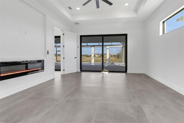 unfurnished room featuring a glass covered fireplace, visible vents, baseboards, and recessed lighting