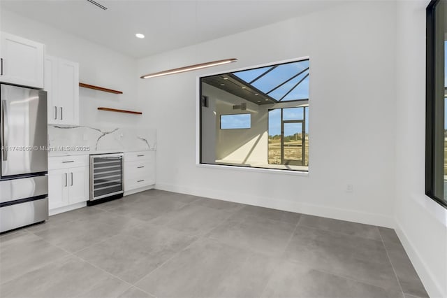 kitchen featuring beverage cooler, white cabinets, freestanding refrigerator, light countertops, and open shelves