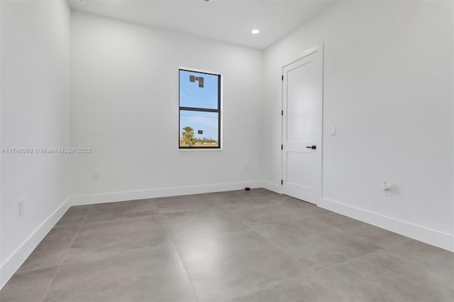 empty room featuring baseboards and recessed lighting