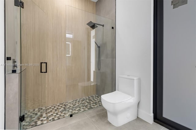 bathroom featuring a stall shower, tile patterned flooring, and toilet