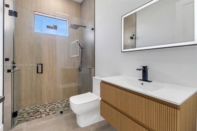 bathroom with tile patterned floors, a shower stall, toilet, and vanity