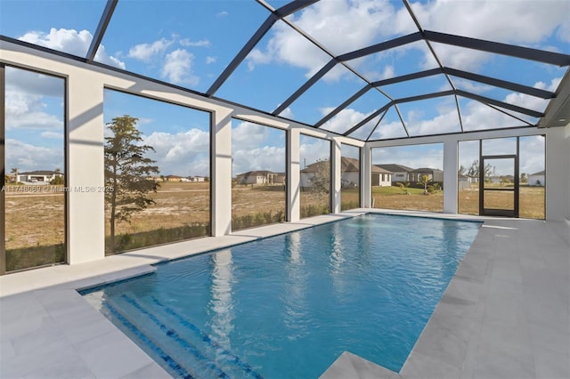 outdoor pool featuring glass enclosure and a patio area