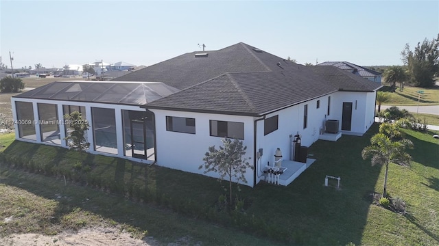 view of side of property with roof with shingles, stucco siding, a lawn, glass enclosure, and cooling unit