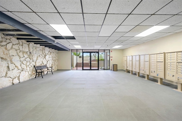 interior space featuring a mail area, light tile patterned flooring, and a paneled ceiling