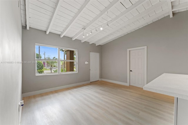 empty room with vaulted ceiling with beams, rail lighting, light wood-style flooring, wood ceiling, and baseboards