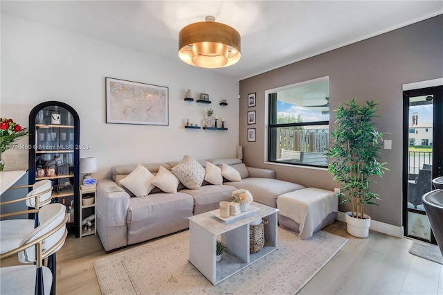 living area featuring baseboards and light wood-style floors