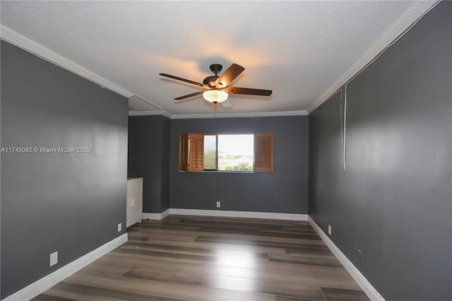 empty room featuring dark wood-style floors, ceiling fan, ornamental molding, and a textured ceiling