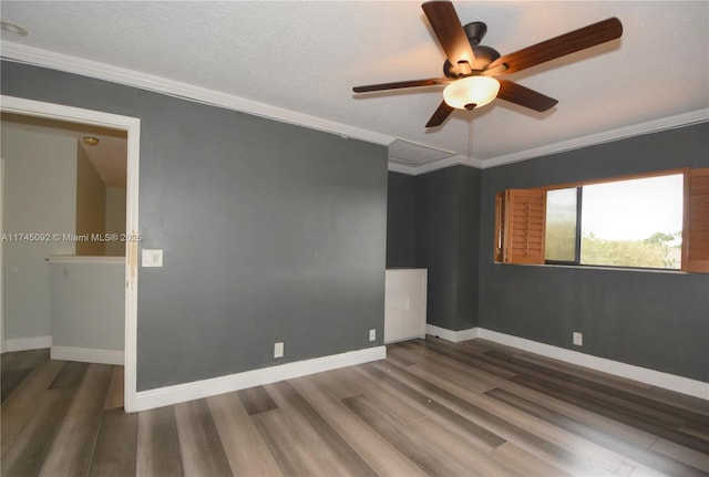 unfurnished room with baseboards, dark wood-style floors, ceiling fan, ornamental molding, and a textured ceiling