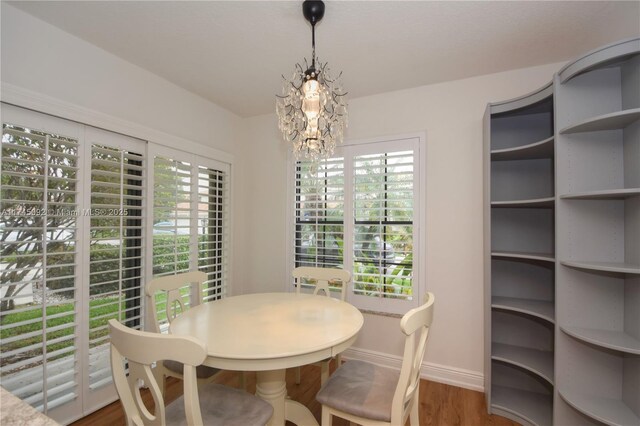 8639 Eagle Run Dr Unit 11, Boca Raton, FL 33434 - dining area with baseboards, a chandelier, and wood finished floors