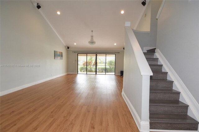 8639 Eagle Run Dr Unit 11, Boca Raton, FL 33434 - unfurnished living room with stairway, light wood finished floors, lofted ceiling, ornamental molding, and recessed lighting