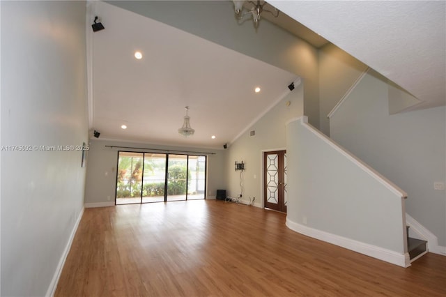 8639 Eagle Run Dr Unit 11, Boca Raton, FL 33434 - unfurnished living room featuring stairs, lofted ceiling, wood finished floors, crown molding, and baseboards