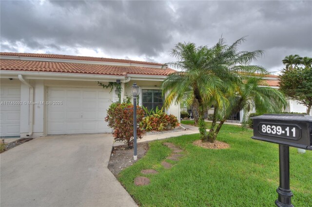 8639 Eagle Run Dr Unit 11, Boca Raton, FL 33434 - view of front of property featuring a tile roof, concrete driveway, a garage, a front yard, and stucco siding