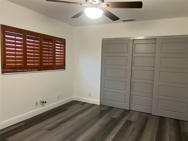 8639 Eagle Run Dr Unit 11, Boca Raton, FL 33434 - unfurnished bedroom featuring dark wood-type flooring, baseboards, a closet, and ceiling fan