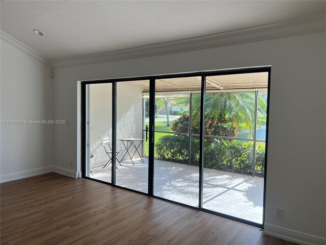 8639 Eagle Run Dr Unit 11, Boca Raton, FL 33434 - empty room with wood finished floors, crown molding, baseboards, and a textured ceiling