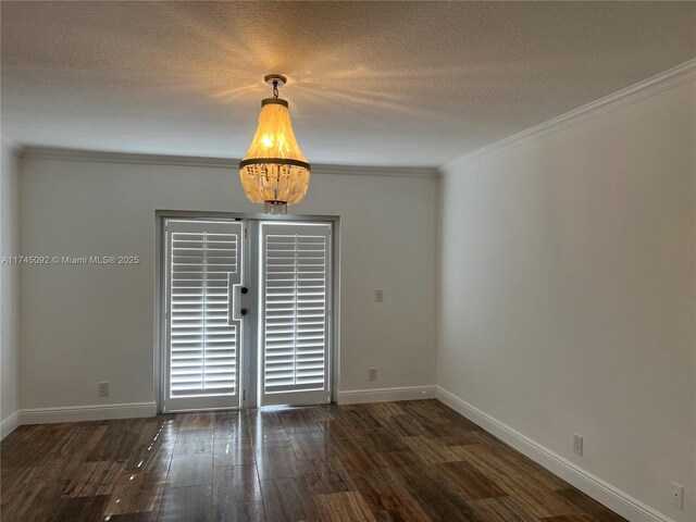 8639 Eagle Run Dr Unit 11, Boca Raton, FL 33434 - empty room with wood finished floors, baseboards, ornamental molding, a textured ceiling, and a chandelier