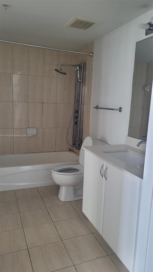 full bathroom with tile patterned floors, toilet, vanity, and tiled shower / bath combo