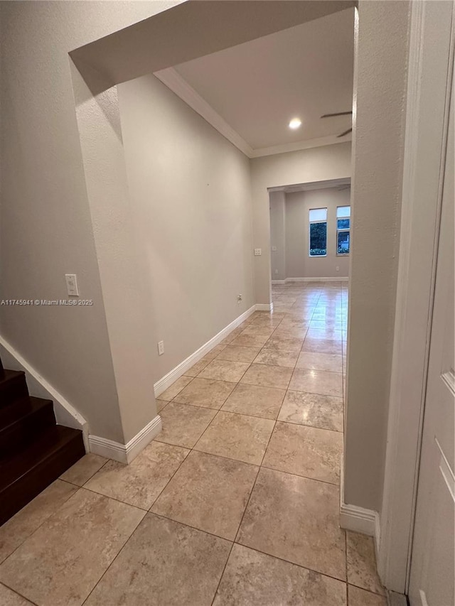 hallway featuring ornamental molding and light tile patterned floors