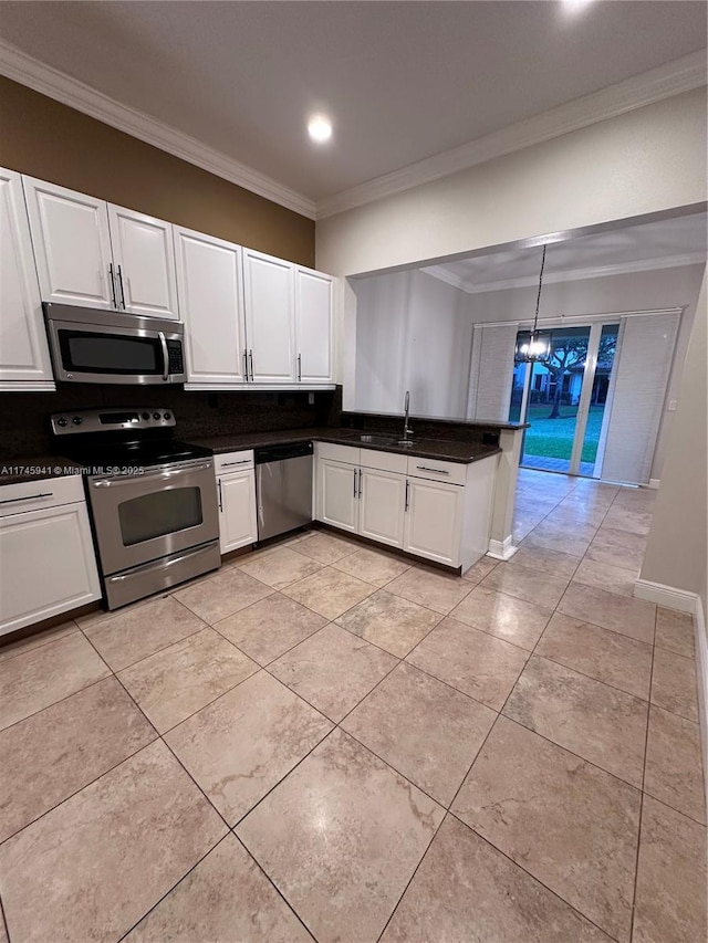 kitchen featuring white cabinetry, kitchen peninsula, decorative light fixtures, appliances with stainless steel finishes, and crown molding