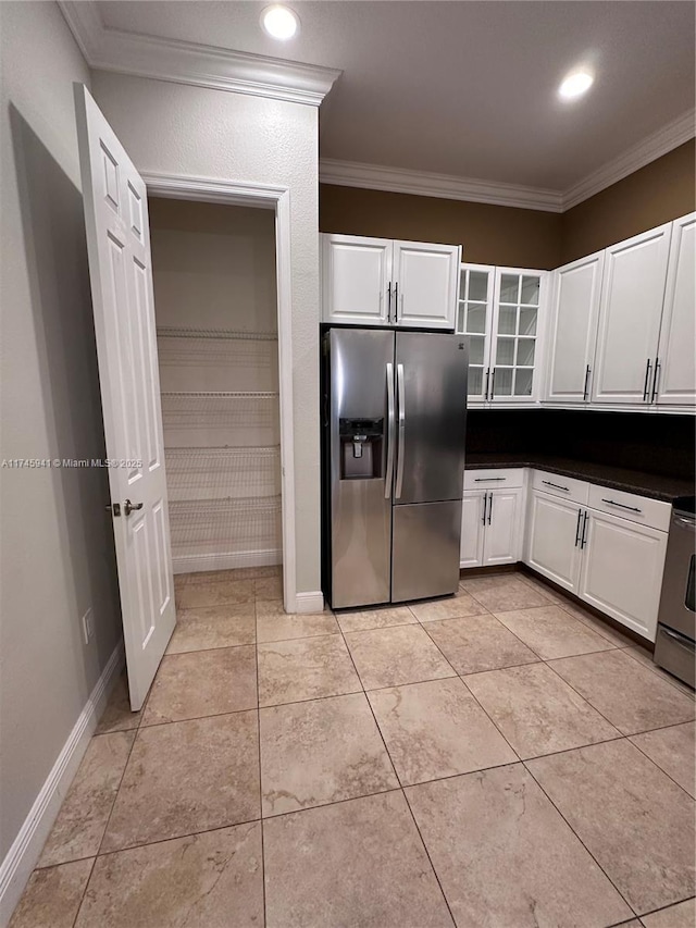 kitchen featuring ornamental molding, light tile patterned flooring, stainless steel appliances, and white cabinetry