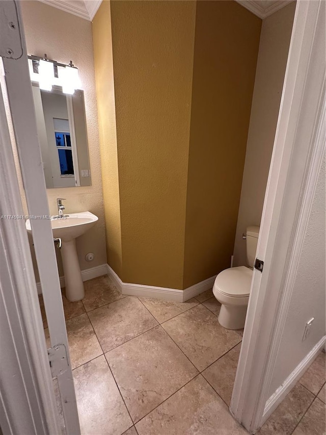 bathroom featuring toilet, tile patterned flooring, and crown molding