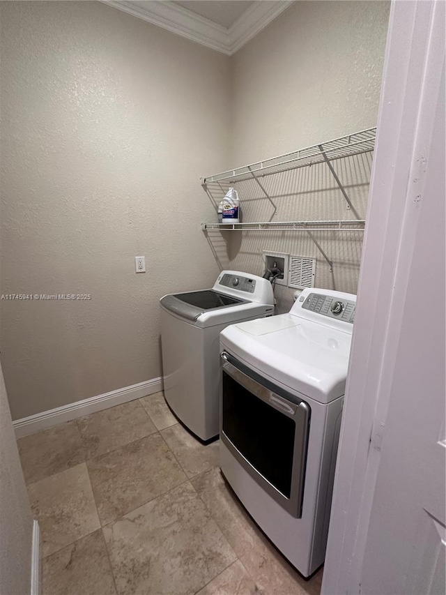 washroom featuring washer and dryer and ornamental molding