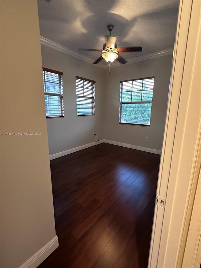 unfurnished room featuring a textured ceiling, dark wood-type flooring, crown molding, and ceiling fan